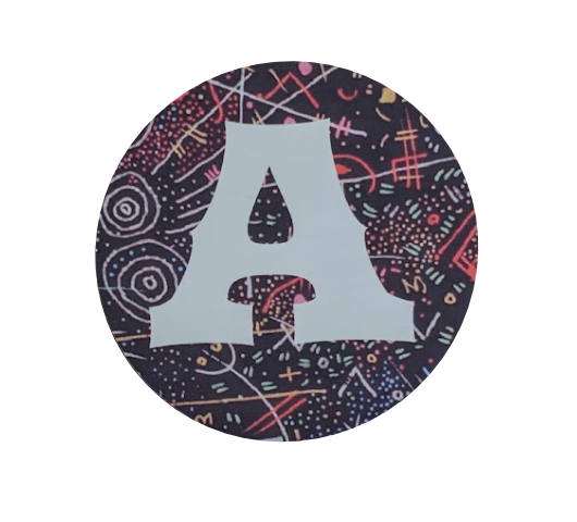 A circular coaster featuring a large light gray letter 'A' on a dark navy background with a multicolor abstract doodle pattern.