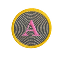 A circular embroidered patch featuring a yellow fringe border, a gray concentric spiral pattern, and a pink embroidered letter 'A' in the center, shown on a plain white background.