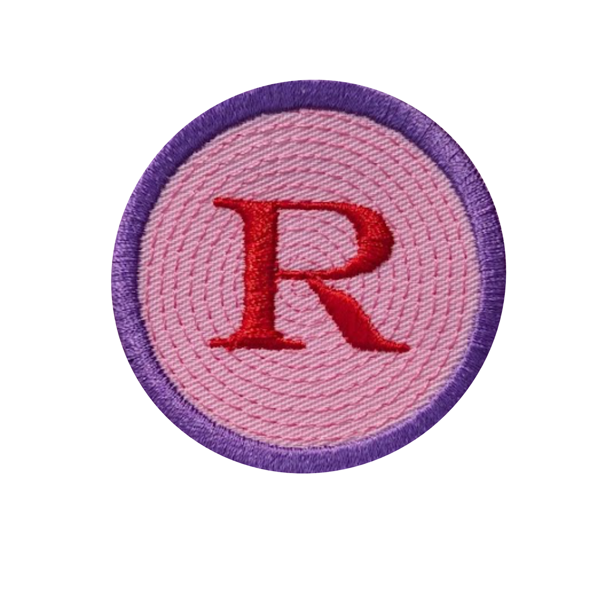 A circular embroidered patch featuring a large red letter 'R' in the center, surrounded by a pink stitched background and a purple embroidered border, shown on a plain white background.